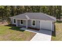 Beautiful single-story home featuring a gray exterior, well-manicured lawn, and an attached one car garage at 13237 Sw 114 Pl, Dunnellon, FL 34432