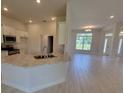 Bright, open kitchen with granite countertops and white cabinets overlooking a living area with large windows at 11610 Sw 59Th Terrace, Ocala, FL 34476