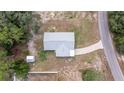 Aerial view of a well-maintained home and property including a driveway, shed, and tree coverage at 30 Maple Crse, Ocklawaha, FL 32179