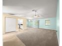 Spacious open-concept living room boasts carpet flooring, neutral walls, ceiling fan, and easy access to the kitchen at 4219 Ne 33Rd Ave, Ocala, FL 34479