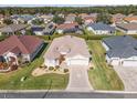 Aerial view of a single-story home with a well-manicured lawn, landscaped front yard, and a driveway with a star design at 10927 Se 168Th Loop, Summerfield, FL 34491
