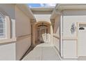 Inviting front entrance with stucco walls, columns, a transom window, and decorative lighting, adding charm and curb appeal at 10927 Se 168Th Loop, Summerfield, FL 34491