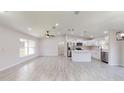 Open-concept living and kitchen area with wood-look tile floors at 11 Emerald Trl, Ocala, FL 34472