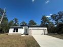 Charming single-story home with stone accents, a two-car garage and a well-manicured lawn at 14711 Sw 69Th Court Rd, Ocala, FL 34473