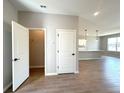 Light interior featuring closet with an open door and wood-look tile floors leading to the kitchen area at 2647 Sw 154Th Ln, Ocala, FL 34473