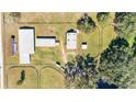 Aerial view showing multiple barns and paddocks on a large equestrian property at 10555 W Highway 40, Ocala, FL 34482