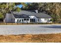 White ranch house with black trim, grey roof and riding arena at 10555 W Highway 40, Ocala, FL 34482