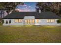 White brick home with black windows and trim at dusk at 10555 W Highway 40, Ocala, FL 34482