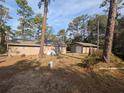 Exterior view of the house and garage with a backdrop of tall trees, offering a sense of privacy and tranquility at 14830 Se 61St Street Rd, Ocklawaha, FL 32179