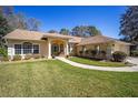 Well-maintained home featuring a lush lawn and inviting walkway to the front entrance at 19009 Sw 98Th Loop, Dunnellon, FL 34432