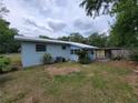 View of home's backyard, showcasing a covered patio and mature trees for relaxing outdoor living at 2605 Ne 14Th Ave, Ocala, FL 34470