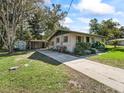 Cozy home showcasing a metal roof, a carport, and mature landscaping at 2605 Ne 14Th Ave, Ocala, FL 34470