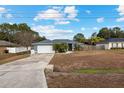 One-story home with gray siding, attached garage, and driveway at 35 Teak Rd, Ocala, FL 34472