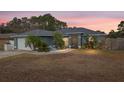 House exterior at dusk, gray siding, white garage door, landscaping at 35 Teak Rd, Ocala, FL 34472