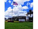 Del Webb Stone Creek community entrance featuring landscaped grounds, flagpole and blue skies in the background at 7066 Sw 91St Ct, Ocala, FL 34481