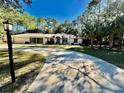 A lovely one-story home with a winding driveway, lush landscaping, and an attached two-car garage at 7535 Sw 185 Avenue Rd, Dunnellon, FL 34432