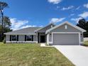 New home exterior featuring a well-manicured lawn and gray color scheme at 8357 Sw 58Th Ave, Ocala, FL 34476