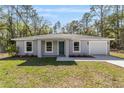 Charming single-story home with grey exterior, well-manicured lawn, and attached garage at 2391 Sw 143 Ct, Ocala, FL 34481