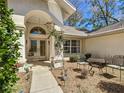 Inviting front patio and seating area lead to the double glass front door at 9805 Sw 190Th Terrace Rd, Dunnellon, FL 34432