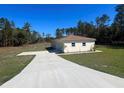 Home with an attached garage and a long driveway on a clear day at 12205 Sw 71St Lane Rd, Ocala, FL 34481