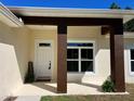 Inviting front porch with modern columns, white trim window and door, adorned with plants and welcome mat for a warm entrance at 12205 Sw 71St Lane Rd, Ocala, FL 34481