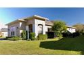 Tan house with white columns, landscaping, and a black fence at 3642 Nw 55Th Cir, Ocala, FL 34482