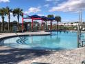 Resort-style pool with shade umbrellas and lounge chairs at 547 Tanaro Ln, Haines City, FL 33844