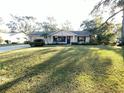 White brick ranch house with a spacious lawn and mature trees at 12467 Se 62Nd Ave, Belleview, FL 34420