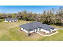 Well maintained single-story home with a dark roof, white siding, and manicured landscaping at 1725 W Hwy 329, Citra, FL 32113