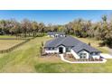 Stunning single-story home with a fenced lawn, dark roof, white siding, and manicured landscaping at 1725 W Hwy 329, Citra, FL 32113