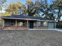 Newly built house with gray siding, brick accents, and a covered porch at 4131 Se 130Th Pl, Belleview, FL 34420