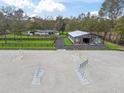Aerial shot featuring the well-maintained horse riding arena with jumps, barn, and surrounding landscape at 965 Nw 73Rd Ter, Ocala, FL 34482