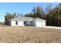 One-story house with white siding, gray roof, and a stone accent at 13441 Sw 113Th Pl, Dunnellon, FL 34432