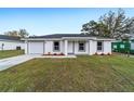 Attractive single-story home with a well-kept lawn, showcasing its inviting curb appeal and attached garage at 10177 Sw 137Th Ct, Dunnellon, FL 34432