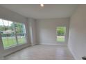 Light, bright bedroom with a large window overlooking the front yard and tile floors at 11503 Sw 65Th Avenue Rd, Ocala, FL 34476