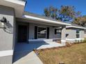 Inviting front porch featuring a modern light fixture and new landscaping at 7613 Sw 103Rd Loop, Ocala, FL 34476