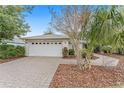 White house exterior with a paver driveway and neatly landscaped yard at 8718 Sw 83Rd Loop, Ocala, FL 34481