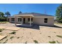 A view of the rear exterior featuring a covered porch and freshly prepped yard at 9679 Sw 46Th Ct, Ocala, FL 34476