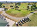 Aerial view of golf course community with palm trees, golf carts, and clubhouse at 5226 Nw 21St Loop, Ocala, FL 34482