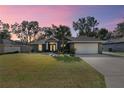 House exterior at dusk with a well-manicured lawn at 8448 Se 161St St, Summerfield, FL 34491