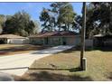 Front view of a green house with a brown roof and driveway at 35 Hemlock Terrace Dr, Ocala, FL 34472