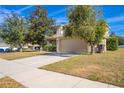 Two-story house with tan exterior, attached garage, and landscaping at 3921 Sw 51St Ter, Ocala, FL 34474