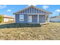 Gray house with white trim and a covered porch, showcasing curb appeal at 3496 Sw 149Th Ct, Ocala, FL 34481