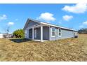 Side and back of the home showcases a well-maintained exterior with large windows and a neat backyard at 3496 Sw 149Th Ct, Ocala, FL 34481