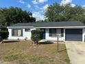 Attractive single-story house with a blue door, shutters, attached garage, and neatly kept lawn at 41 Hickory Trak, Ocala, FL 34472