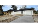 New concrete driveway leading up to the one car garage with matching exterior lights at 519 Sw 19Th Ave, Ocala, FL 34471