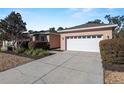 Front view of a single-story house with a white garage door at 7947 Sw 80Th Place Rd, Ocala, FL 34476