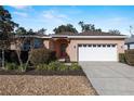 Single-story house with a white garage door and neatly landscaped yard at 7947 Sw 80Th Place Rd, Ocala, FL 34476