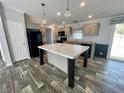 Bright kitchen with stainless steel appliances, central island, and wood-look laminate flooring at 11605 Nw 20Th St, Ocala, FL 34482