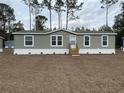 Single-wide manufactured home with grey siding and a wood-toned front door at 11625 Nw 20Th St, Ocala, FL 34482